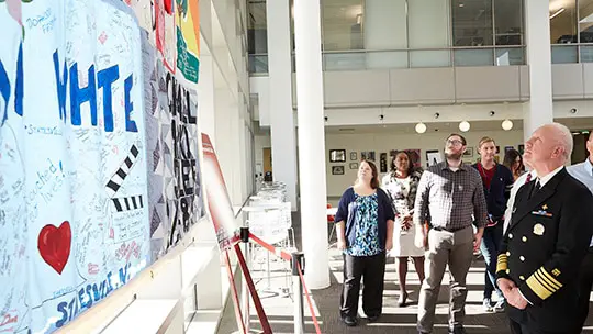 Adm. Brett Giroir and a group of employees from the Food and Drug Administration look up at the AIDS Memorial Quilt display.