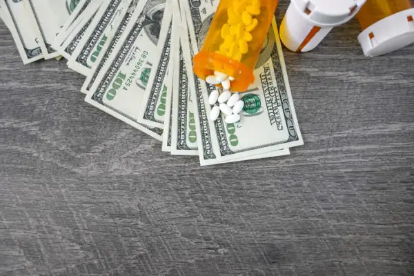 Money pile and medicine pills representing medical expenses