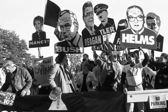 Members of AIDS activist group ACT UP hold up signs of George W. Bush, Ronald Reagan, Nancy Reagan, and Jesse Helms with the word "Guilty" stamped on their foreheads at a protest at the headquarters of the Food and Drug Administration in Rockville, Maryland.