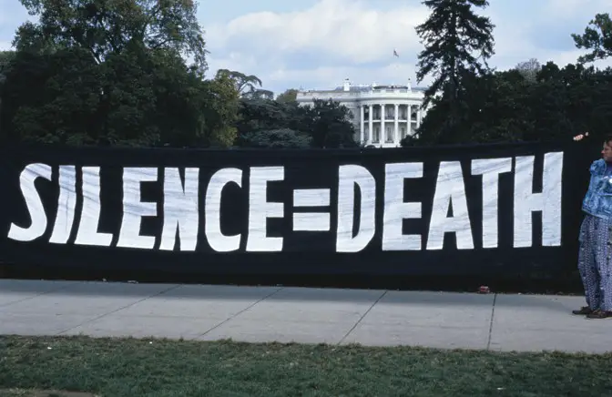 AIDS protest in front of the White House. ACT UP activists hang a "silence = death" banner on the White House gates