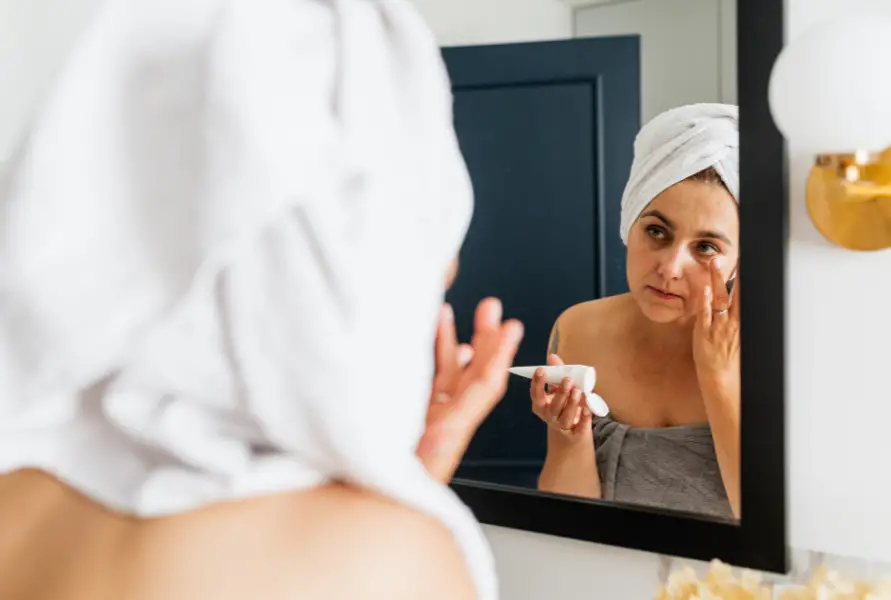 Mirror-Reflection-of-a-Woman-Applying-Face-Cream