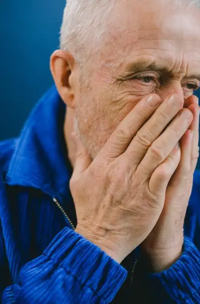 Senior man covering mouth with hands